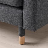 Nahaufnahme eines modernen Sofabeins aus Holz und Stoff auf einem Holzboden.