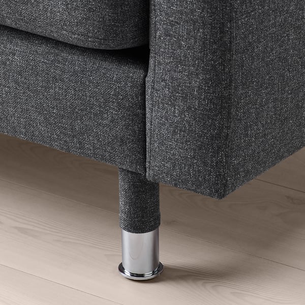 Sofa aus dunklem Stoff mit verchromten Beinen, das sich durch hochwertige Verarbeitung und bequeme Polsterung auszeichnet.
