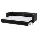 Schwarzes ausziehbares Sofa mit Lederbehandlungen, Metallbeinen und Rückenkissen, die auf Komfort und Stauraum ausgelegt sind.