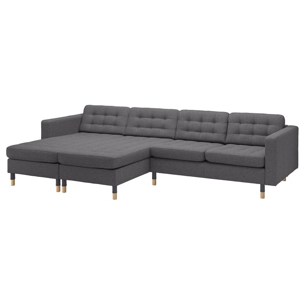 Dunkelgraues L-förmiges Stoffsofa mit Holzbeinen, Plüschkissen und klaren Linien.