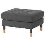 Ein LANDSKRONA Fußhocker aus dunkelgrauem Stoff mit Holzbeinen und Diamant-Tufting.