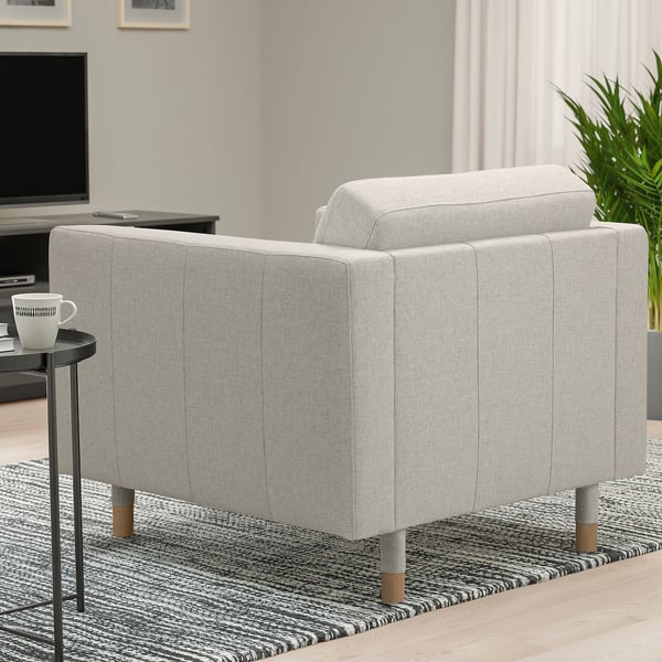 Grauer LANDSKRONA Sessel im Wohnzimmer, schlank und modern mit Holzbeinen, auf gemustertem Teppich neben kleinem Tisch mit Becher.