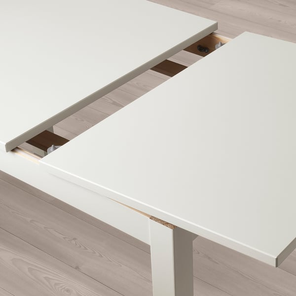 Weißer ausziehbarer LANEBERG-Esstisch mit Blatt darunter, Platz für 4-6 Personen, auf Holzboden.