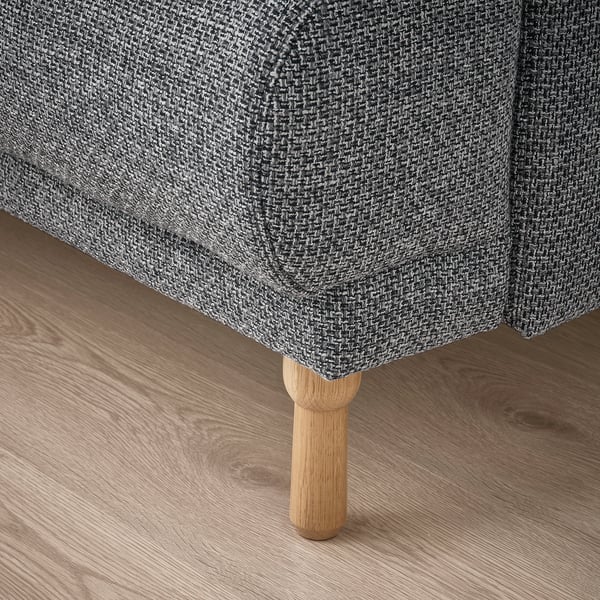 Nahaufnahme der LÅNGARYD-Sofas mit robustem, gedrechseltem Eichenbein und weichem, strukturiertem Stoff, die hochwertige Handwerkskunst zeigen.