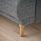 Nahaufnahme der LÅNGARYD-Sofas mit robustem, gedrechseltem Eichenbein und weichem, strukturiertem Stoff, die hochwertige Handwerkskunst zeigen.