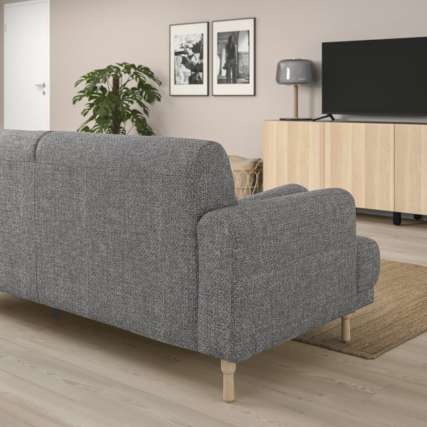 Ein modernes graues LÅNGARYD-Sofa mit Holzbeinen in einem Wohnzimmer. Es ist größer als andere Möbel und bietet ausreichend Sitzgelegenheiten.