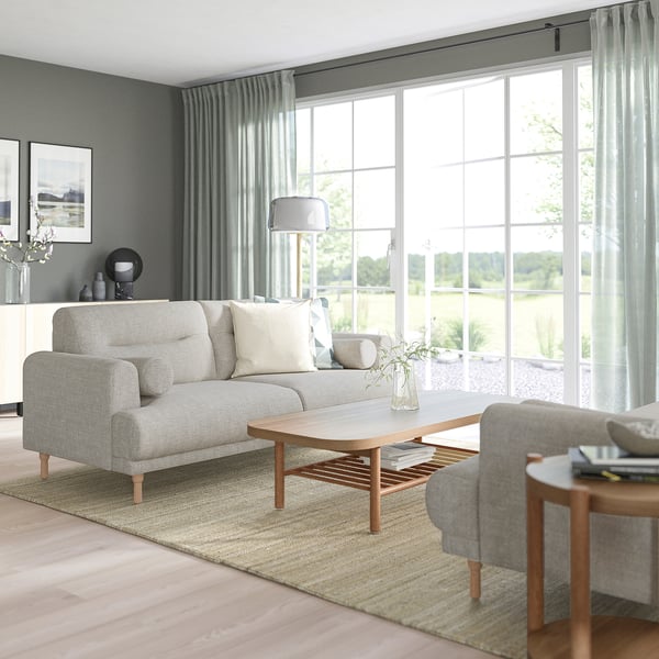 Modernes Wohnzimmer: graues LÅNGARYD-Sofa, Couchtisch aus Holz, großes Fenster, Lichtvorhänge. Geräumiges, gemütliches Design.