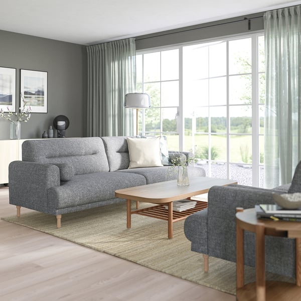 Modernes Wohnzimmer mit grauem LÅNGARYD-Sofa, blauem Stuhl, Holztisch und großem Fenster.