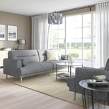 Modernes Wohnzimmer mit grauem LÅNGARYD-Sofa, Tageslicht, großen Fenstern, passendem Sessel, Glascouchtisch und Dekor.