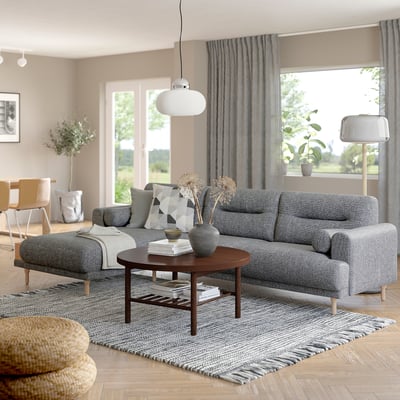Modernes Wohnzimmer mit grauem LÅNGARYD-Sofa, großem und gemütlichem Couchtisch aus Holz, stilvoller Einrichtung, großem Fenster mit Vorhängen.
