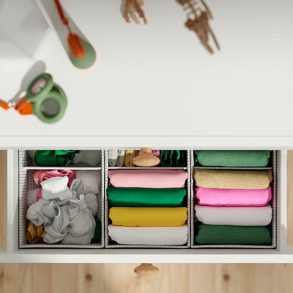 Ordentlich organisierte Schublade mit bunt gefalteten Kleidung, mit verstellbaren Füßen zur Bodennivellierung.