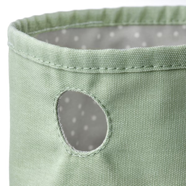 Vorratsbehälter aus grünem Stoff mit kleinem Griff aus recyceltem Polyester, der für die Organisation und Aufbewahrung von Babyutensilien konzipiert ist.