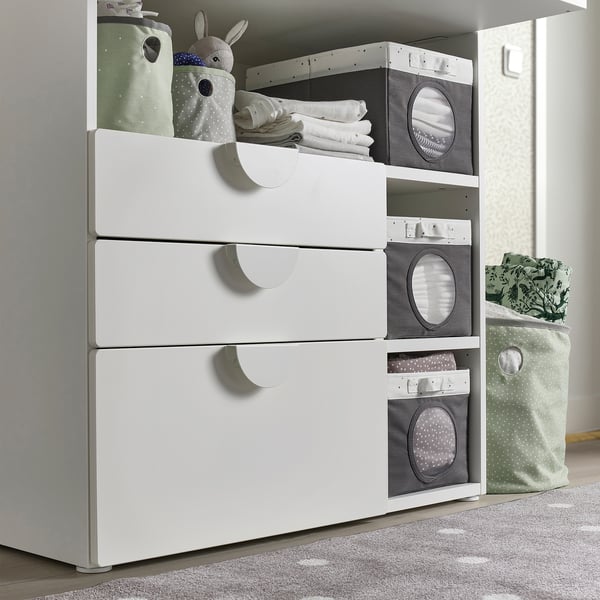 Kinderzimmerschrank mit grauen Behältern bietet Platz für Babykleidung und Spielzeug.