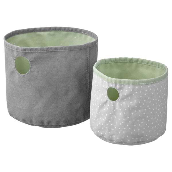 Zwei runde, wendbare Aufbewahrungskörbe, einer grau und einer weiß mit Tupfen, hergestellt aus recyceltem Polyester in Pastellfarben.