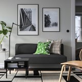 Modernes Wohnzimmer mit grauem LILLEHEM-Sofa, grünem Kissen, Wanddrucken, Pflanze und Couchtisch.
