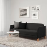Modernes, minimalistisches Wohnzimmer mit schwarzem LINANÄS-Sofa, weißem Beistelltisch und Schwarz-Weiß-Dekor.