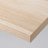 Nahaufnahme einer hellen Tischplatte mit Holzmaserung und glatter, flacher Oberfläche und sauber verarbeiteten Kanten, die hochwertige Handwerkskunst zeigt.