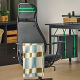 Gaming-Stuhl mit verstellbarer Höhe, Kopfstütze und Kippfunktion. Die Decke hängt an der hinteren Schiene.