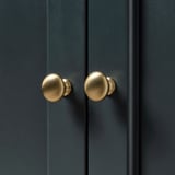Grüner Schrank mit goldenen Knöpfen