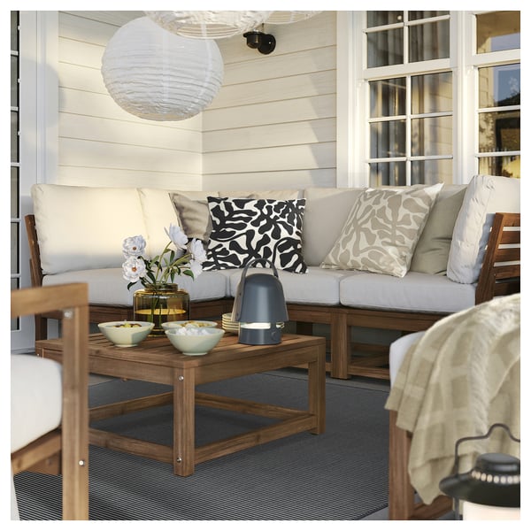 Gemütliche Veranda mit grauem Teppich, Sofa und Dekor.