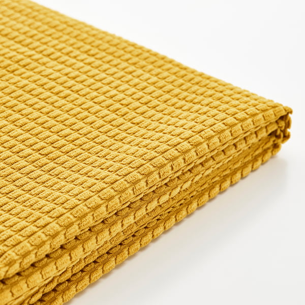 Gefaltetes goldgelbes, strukturiertes Handtuch, wahrscheinlich recyceltes Material, ordentlich ausgestellt auf weißer Oberfläche.