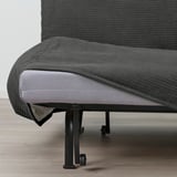 Ein graues Sofa mit einem ausgezogenen Kissen, das die Funktion des umwandelbaren Bettes zeigt. Das Sofa hat ein schwarzes Metallgestell mit Rädern.