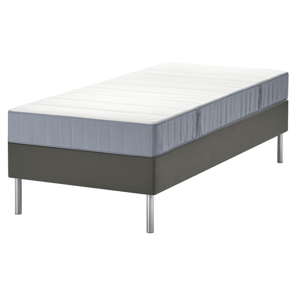 Graues Bett mit weißer Matratze auf grauem Untergestell, modernes Design mit Metallbeinen.