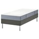 Graues Bett mit weißer Matratze auf grauem Untergestell, modernes Design mit Metallbeinen.