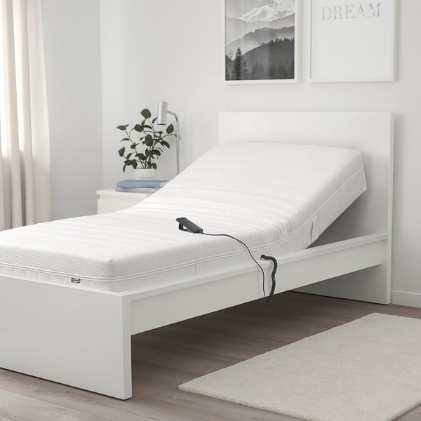 MAJSKÄR Schaumstoffmatratze im minimalistischen Schlafzimmer mit Kippfernbedienung.