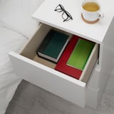 Weißer MALM Nachttisch mit offener Schublade für zwei Bücher, Gläser und eine Teetasse. Sicher für Haushalte mit Kindern.