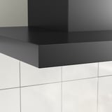 Schwarze moderne Dunstabzugshaube mit schlanken Linien und LED-Beleuchtung, die an einer gefliesten Wand montiert ist.