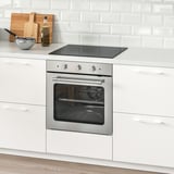 Moderne Küche mit rostfreiem Backofen, weißen Schränken, Keramikrückwand.