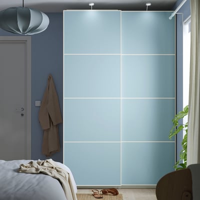 Die zweifarbige blaue Schiebetür von MEHAMN füllt die Wand, die höher ist als das Bett und den Schrank, mit einem schlanken, grifflosen Design.