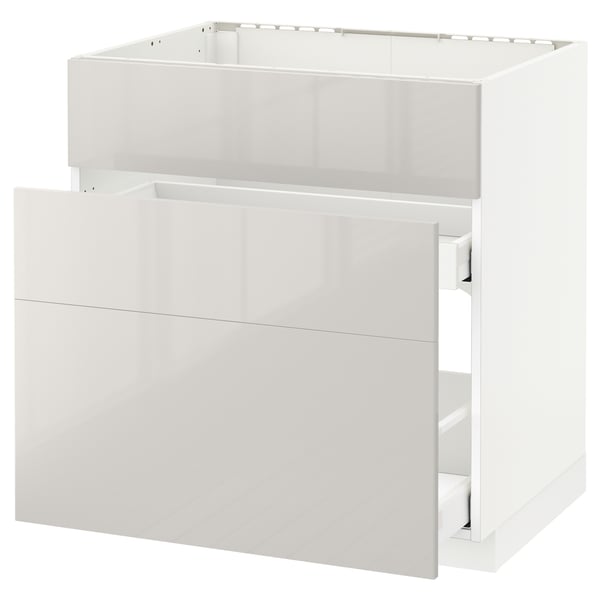 Weißer moderner Küchenschrank mit klaren Linien und Hochglanzschubladen.