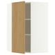 Ein offener METOD-Eckschrank mit heller Eichenoberfläche. Es handelt sich um eine Tür und Regale aus Span- und Faserplatten mit einem modernen, minimalistischen Design.