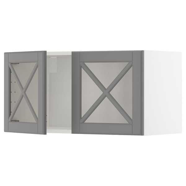 Zwei grau gerahmte Hängeschränke mit abgeschrägten Glastüren in X-förmigem Design.