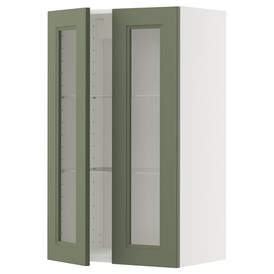 Ein grüner METOD-Küchenschrank mit Glastüren und weißem Rahmen, der ein modernes Design und verstellbare Regale bietet.