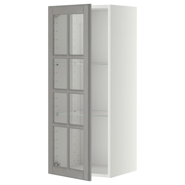 Ein weißer METOD-Wandschrank mit grauen Glastüren, abgeschrägten Kanten und verstellbaren Regalen.