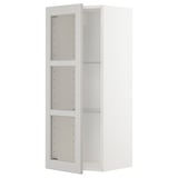 Ein weißer METOD-Küchen-Wandschrank mit verstellbaren Regalen und Glastüren, der für einen modernen, sauberen Look entworfen wurde.