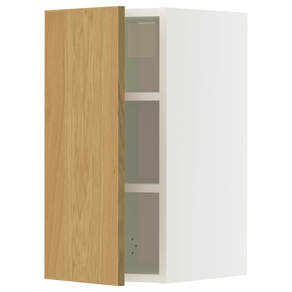 Ein METOD-Wandschrank mit einer hellen Eichentür und einem weißen Rahmen. Er verfügt über drei verstellbare Regale und wird an der Wand montiert.