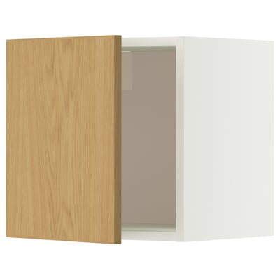 Ein weißer und heller METOD-Wandschrank aus Holz mit einer leicht geöffneten Tür, die im Inneren Glasböden freigibt.