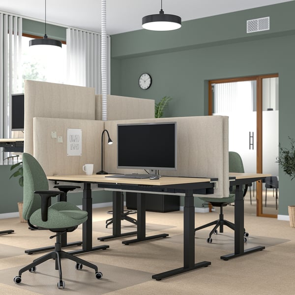 Modernes Büro mit beigen MITTZON-Bildschirmen, grünen Stühlen, Pflanzen und Leuchten.