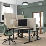 Modernes Büro mit beigen MITTZON-Bildschirmen, grünen Stühlen, Pflanzen und Leuchten.