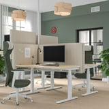 Modernes Büro mit MITTZON-Bildschirmen, Holzlampen und ergonomischen Stühlen. Hohe Akustikschirme bieten Privatsphäre bei hellem, natürlichem Licht.