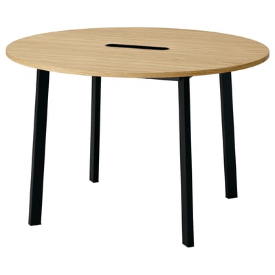 Ein runder Konferenztisch aus Holz namens MITTZON mit vier schwarzen Beinen. Es hat ein schlankes Design und verfügt über ein Kabelmanagement.