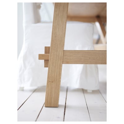 Eine Nahaufnahme eines stilvollen Holztisches mit robustem Bein, das seine hochwertige Eichenoberfläche und sein natürliches Maserungsmuster zur Geltung bringt.