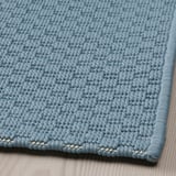 Hellblauer strukturierter Teppich, schön gewebt, flache Oberfläche. Geeignet für den Innen- und Außenbereich.