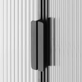Schwarz-Weiß-Nahaufnahme einer schlanken, modernen Schranktür mit strukturiertem Glas und minimalistischem Griff.