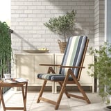 Grau gestreifter NÄMMARÖ Liegestuhl auf dem Balkon mit Tisch, Zeitschrift, Tasse, Obstschale und Pflanze.