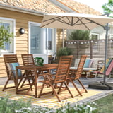 Hinterhofterrasse mit NÄMMARÖ Essgarnitur, Tisch und Stühlen. Beigefarbener Regenschirm, gestreifte Kissen. Gelbes Haus, Grün. Gemütlicher Raum.